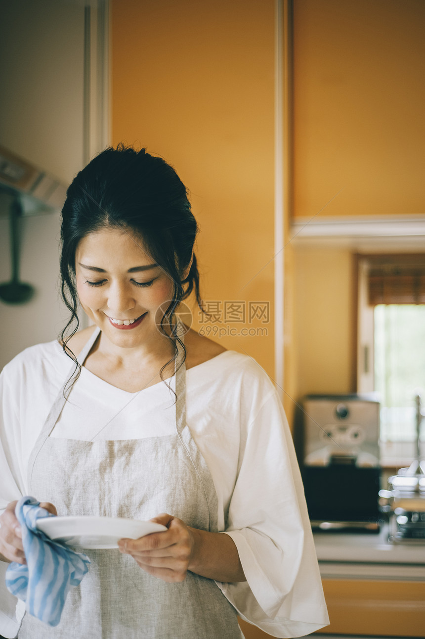 擦盘子的女性图片