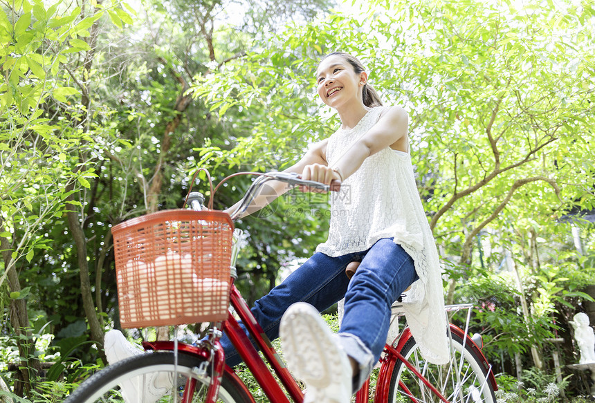 公园骑自行车微笑的年轻女子图片