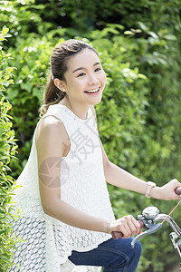 骑着脚踏车开心的年轻女子图片