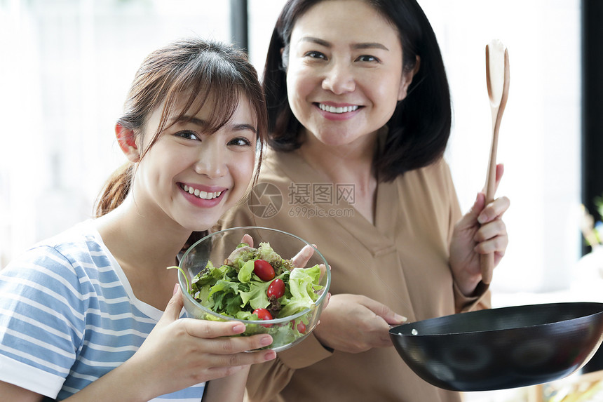 烹饪蔬菜的母女图片