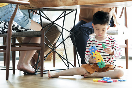小孩在餐桌底下玩玩具图片