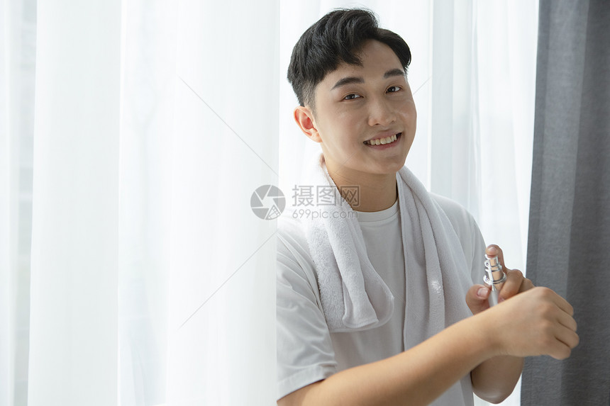 护肤使用精华液的青年男性图片