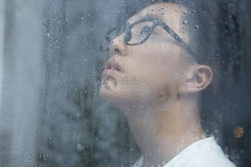 雨天看向窗外的青年男性图片