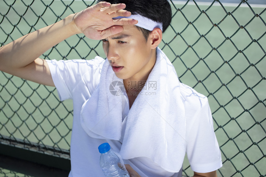 打完网球坐着休息的运动男孩图片