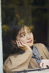 在窗边看书的女性图片