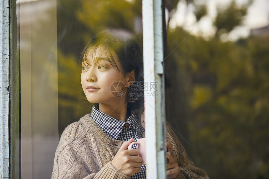 居家女性窗台边喝咖啡图片