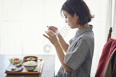 拿着手机拍食物照片的年轻女子图片