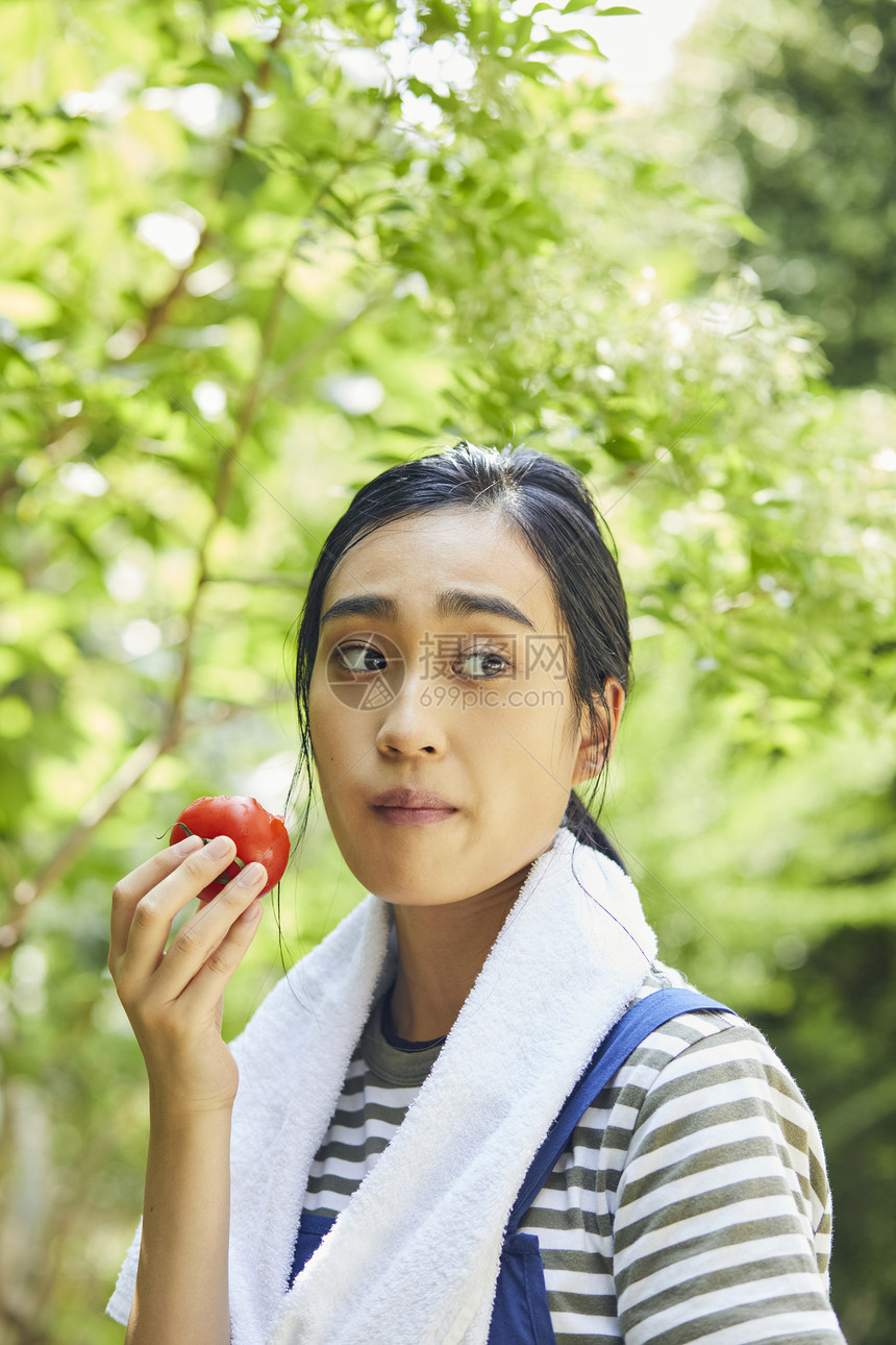 户外吃西红柿的女人图片