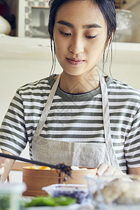 制作午餐盒便当的青年女子图片