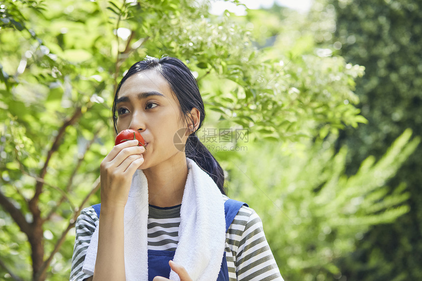 吃番茄的青年女子图片