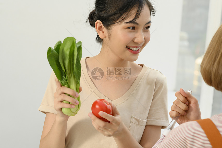 拿着蔬菜微笑的青年女子图片