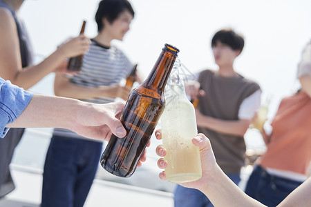 聚会聊天的青年朋友们瓶装啤酒高清图片素材