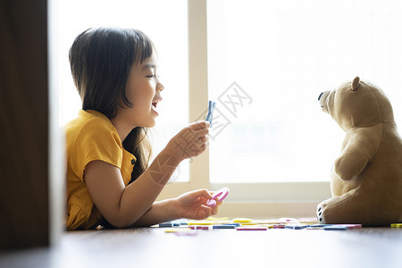 玩玩具熊的女孩小女孩和玩具熊一起学习认识字母背景
