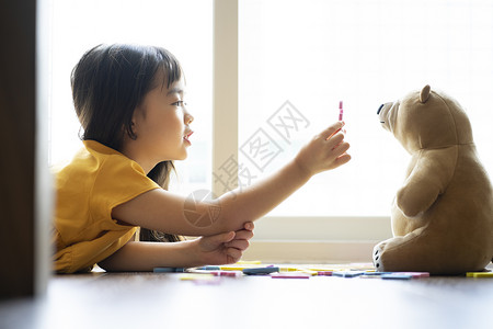玩玩具熊的女孩小女孩和玩具熊一起学习认识字母背景