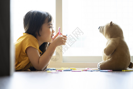 小女孩和玩具熊一起学习认识字母高清图片