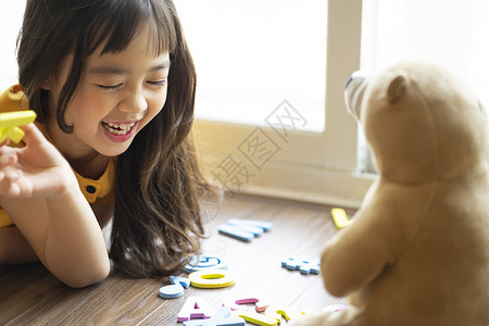 很高兴认识你小女孩和玩具熊一起学习认识字母背景
