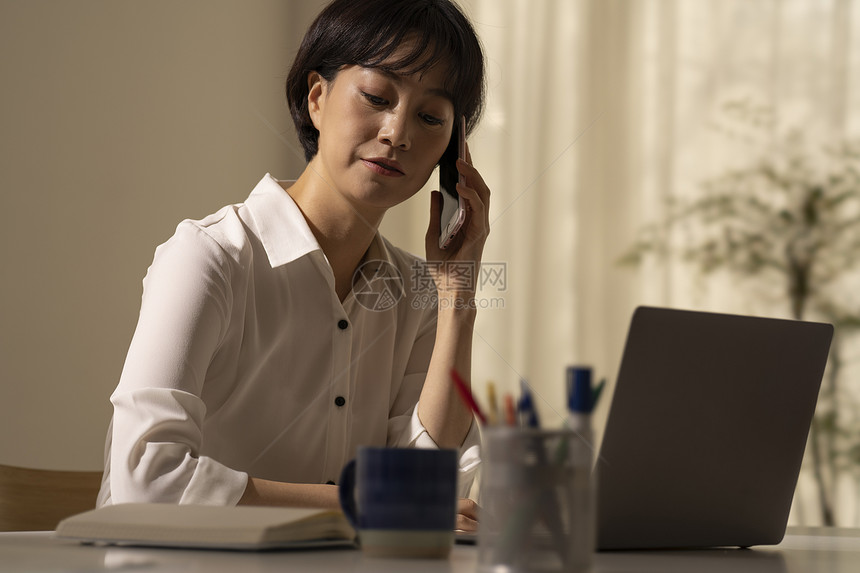 办公桌前打电话的女士图片