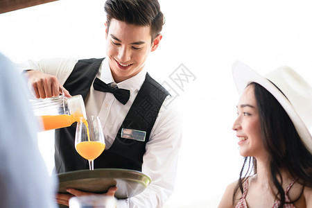 泰国礼服女人服务员为客人倒果汁背景