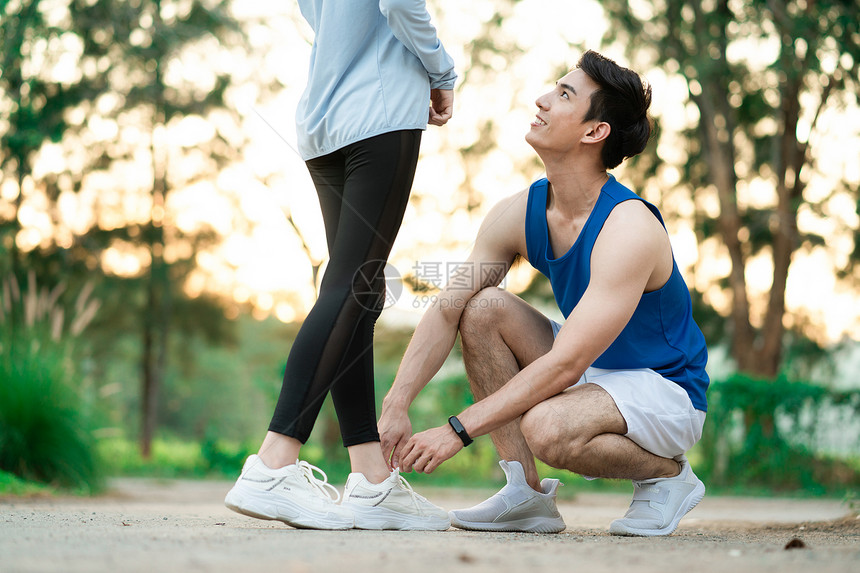 男青年为女朋友系鞋带图片