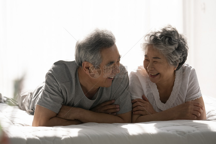 趴在床上开心的老年夫妇图片