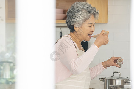 厨房里做饭品尝的老年女性图片
