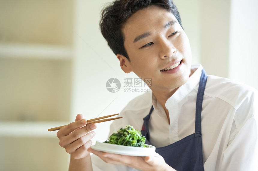手拿筷子品尝的厨师图片