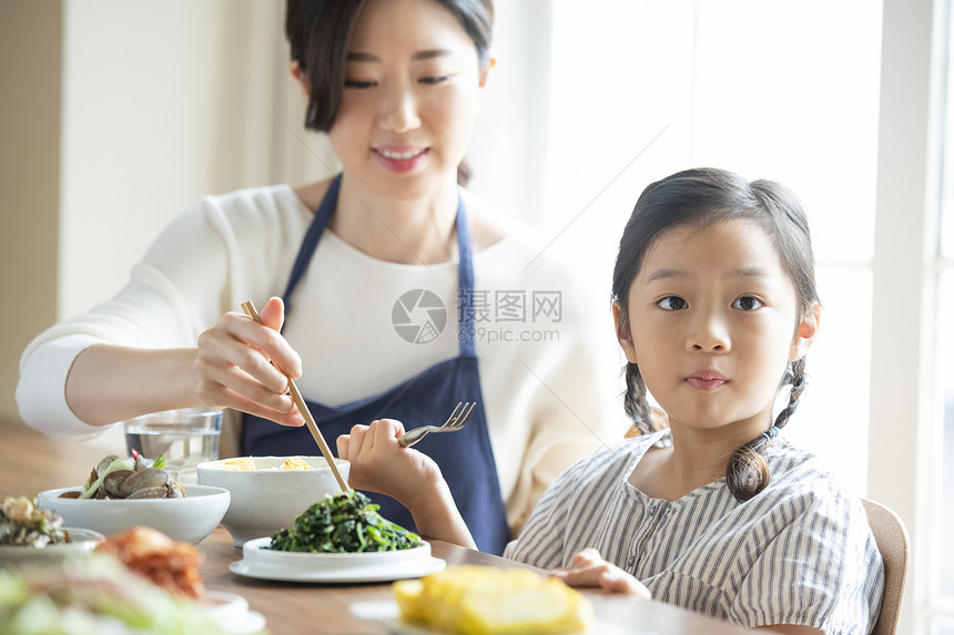 母亲照顾女儿吃饭图片