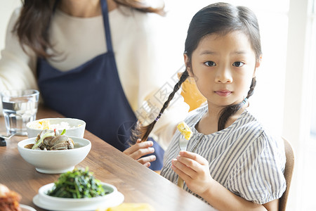 坐在餐桌旁的小女孩图片