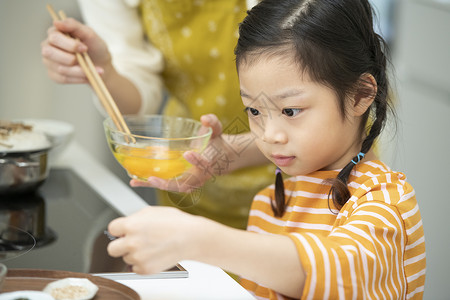 帮助妈妈制作料理的小女孩图片