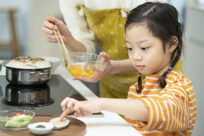 厨房帮助妈妈制作料理的小女孩图片
