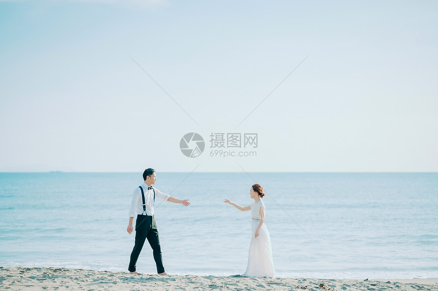 海边窜着婚纱的新人图片