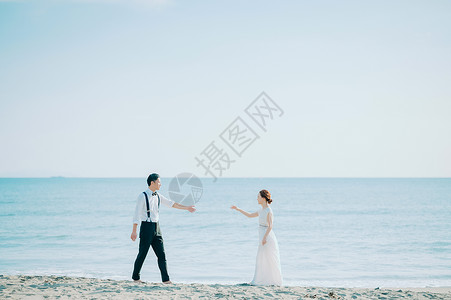 海边窜着婚纱的新人图片