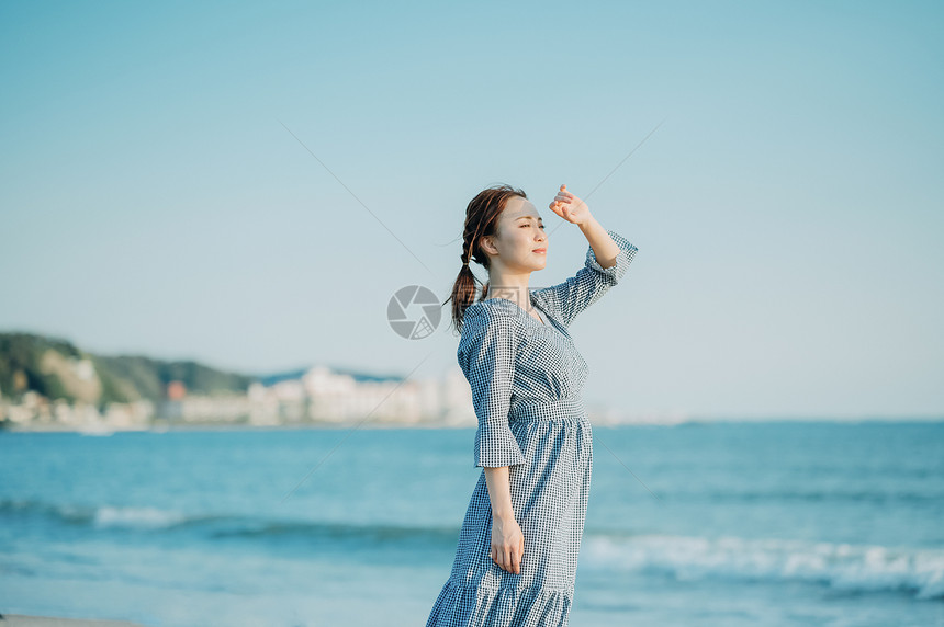 海边散步的青年女子图片