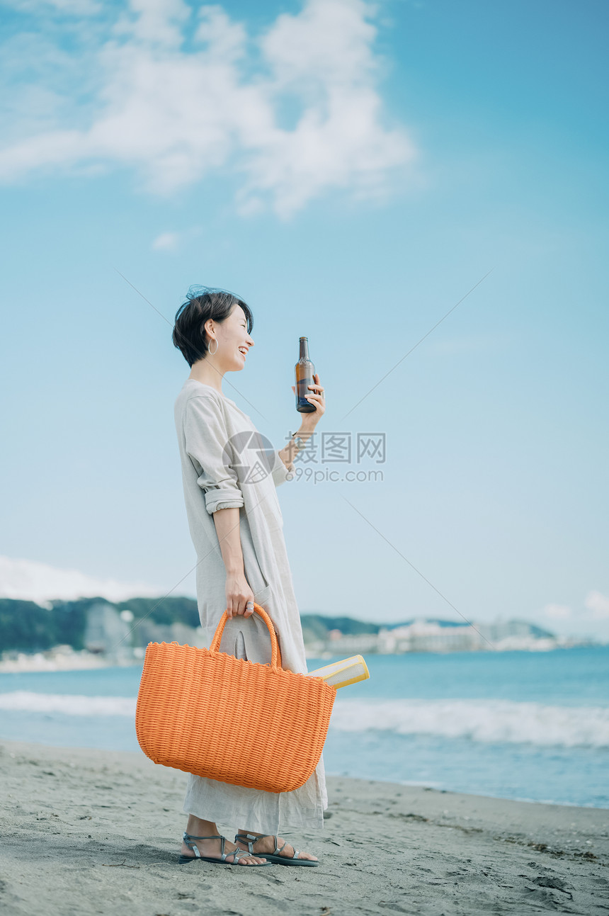 青年女子海边观光喝酒图片
