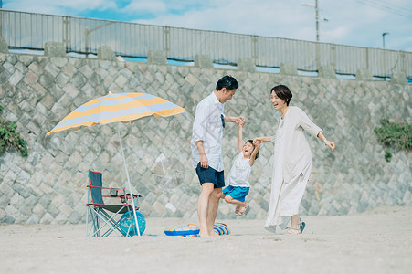 暑假到了一起到海边度假的一家人背景