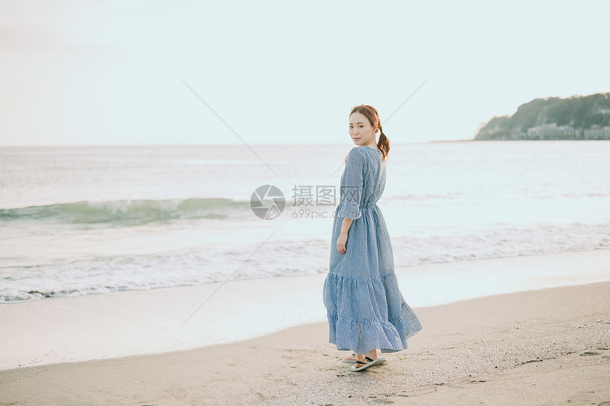 海滩上漫步的年轻女子图片