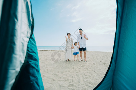 海滩上旅游露营的一家三口背影图片