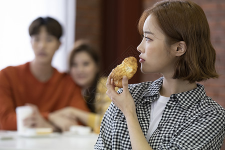 年轻女人吃面包图片