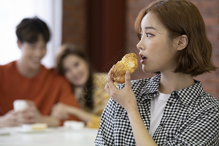 年轻女人吃面包背景图片