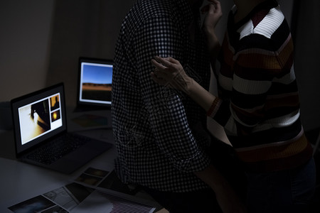 一男一女站在笔记本电脑前图片