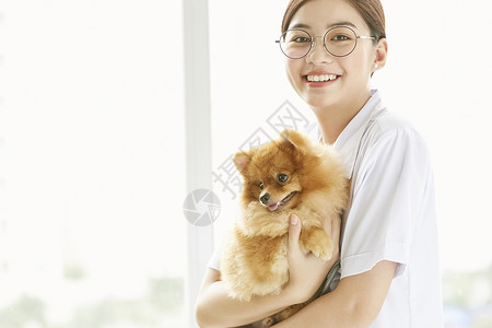 漂亮的宠物医生抱着狗狗图片