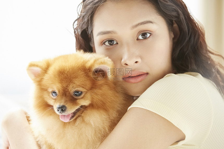 肖像生机勃勃亚洲人和小狗一起生活的年轻女子图片