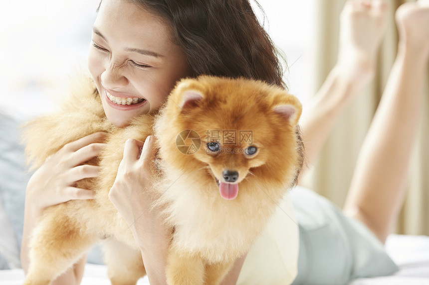 年轻女性开心的抱着狗狗图片