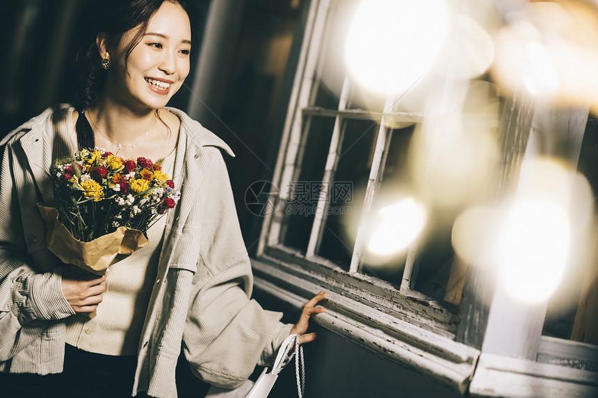 拿着鲜花微笑的年轻女子图片