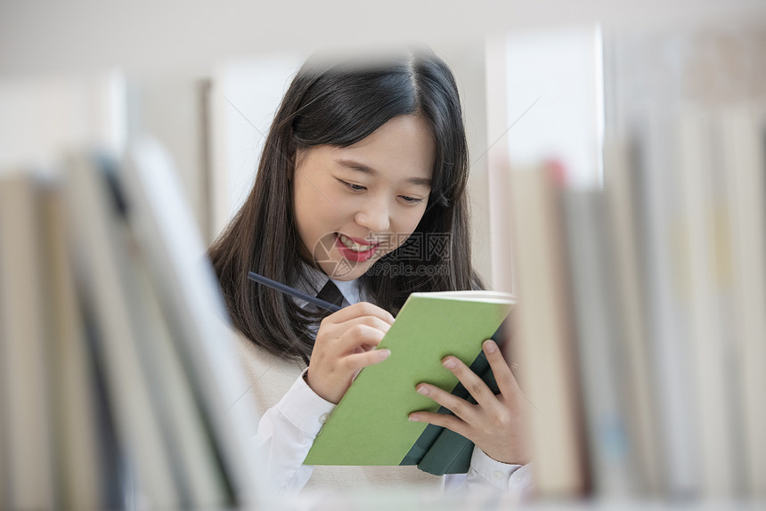 高中女学生在书架上查找书本图片