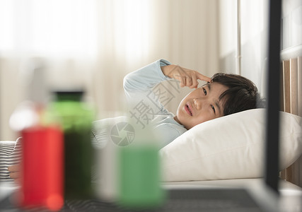 感冒生病的小男孩躺在床上背景图片