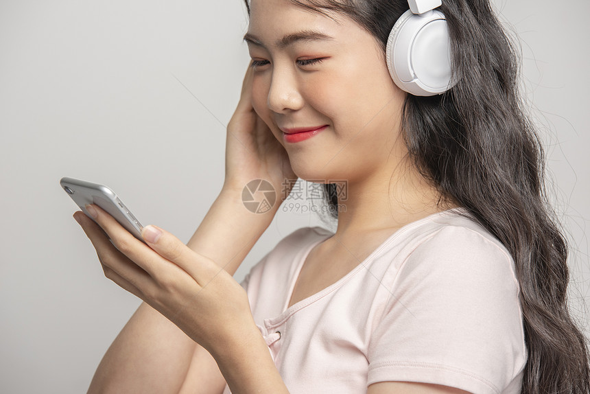 年轻女孩戴着耳机听音乐图片