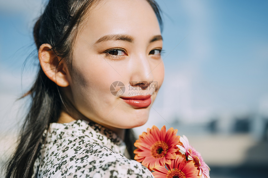 模特儿站立美女拿着花的妇女的画象图片