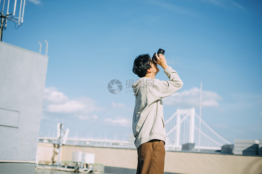 天台上拍照的年轻男人图片