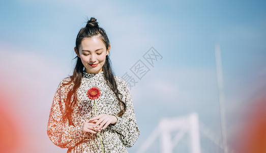 洋装女孩胸前拿着鲜花的青年女子背景